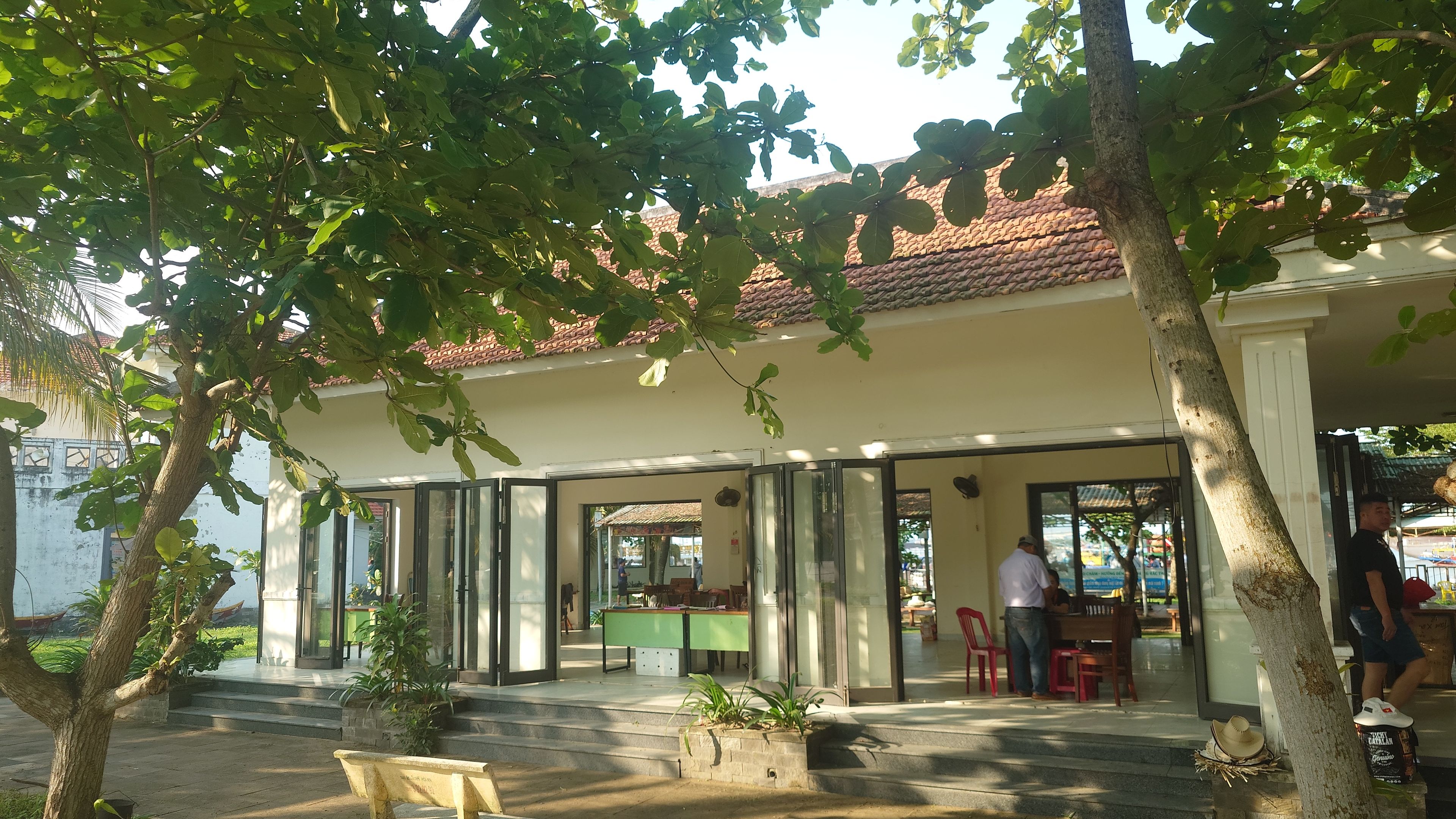 クアダイ港の受付エリア - 複数の建物が並び、案内看板の有無が不規則で分かりにくい様子