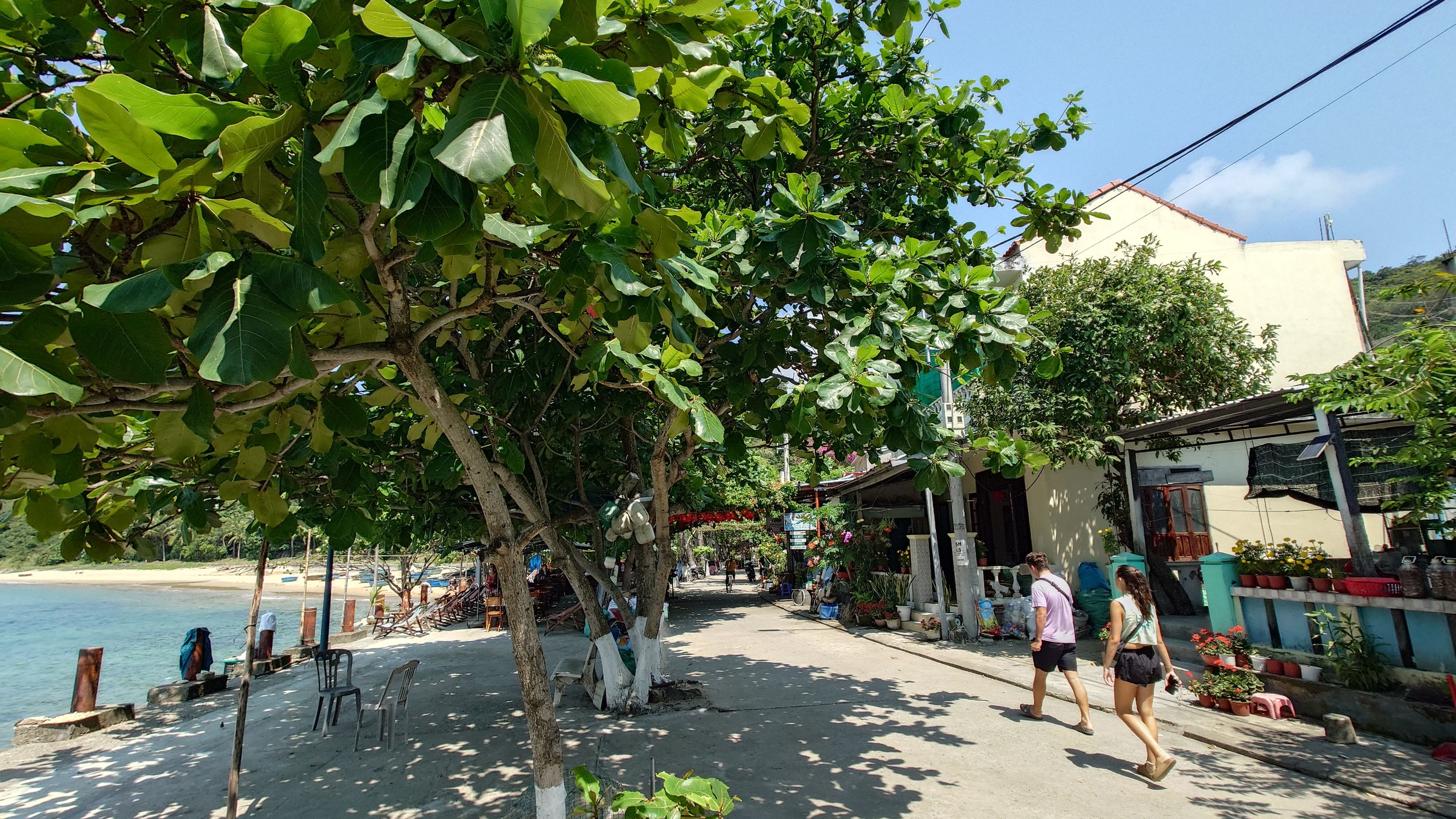 バイフン漁村のメイン通り。日陰のカフェで人々が寛いでいる。