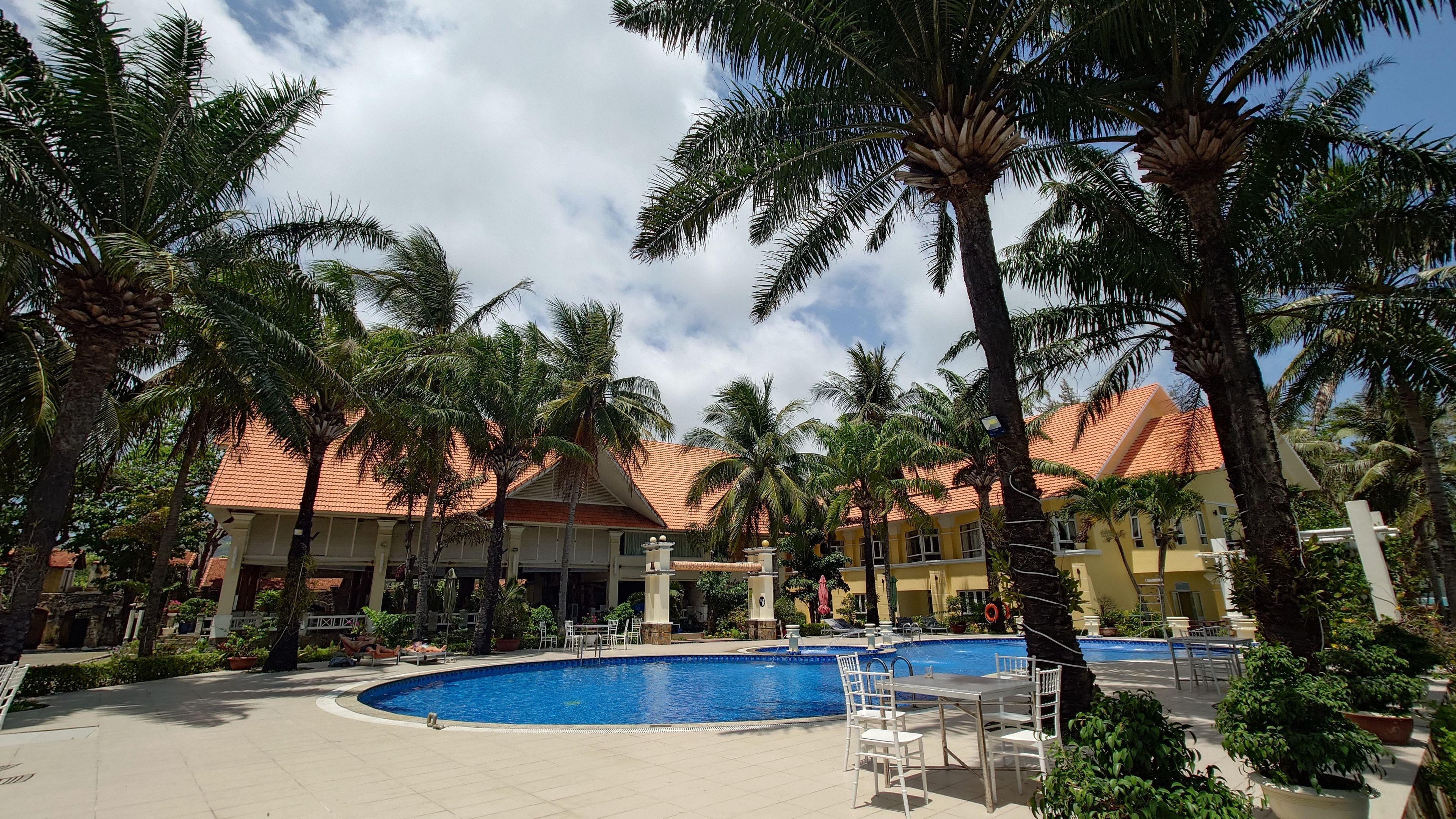 コンダオリゾート：南国の植栽と赤い屋根が美しい、プールサイドから望むホテルの佇まい
