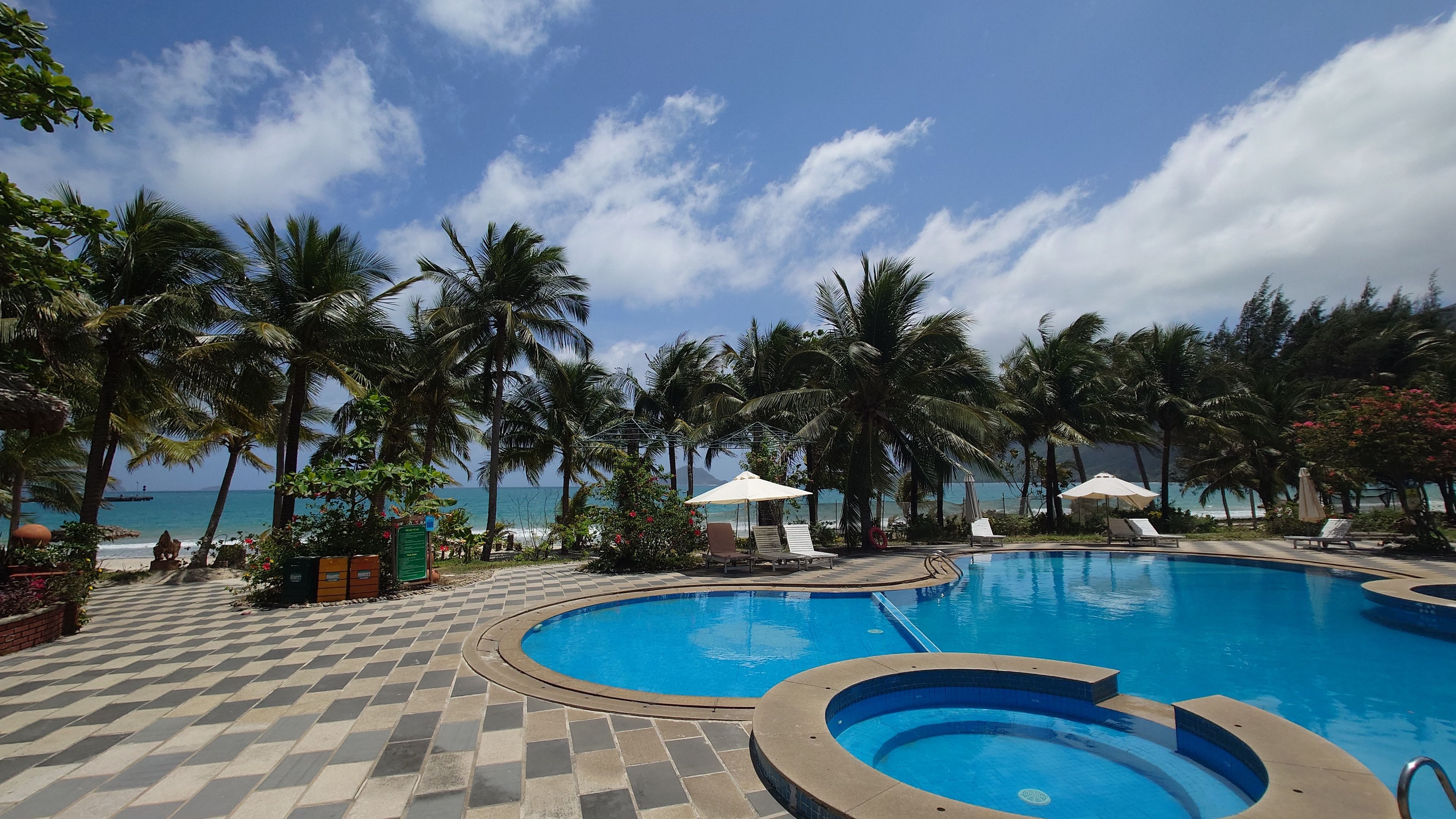 コンダオリゾート：穏やかなプールの水面とその先に続く、透明感あふれるアンハイビーチの海